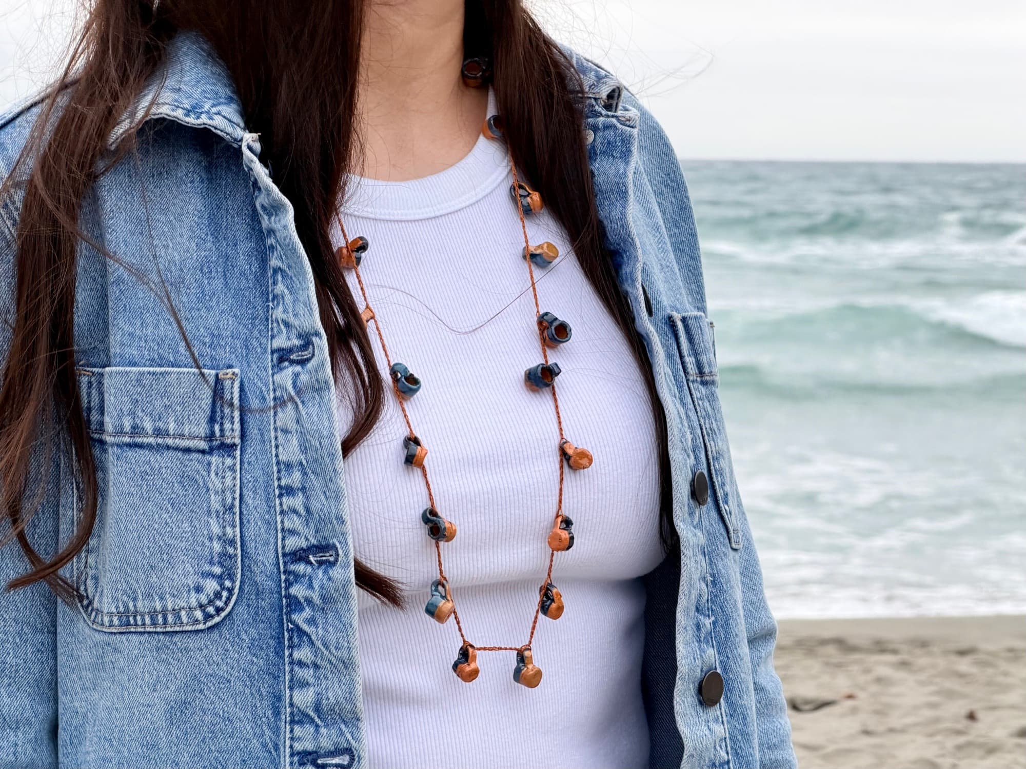 Agua del Río worn with a white top and denim jacket at the beach.