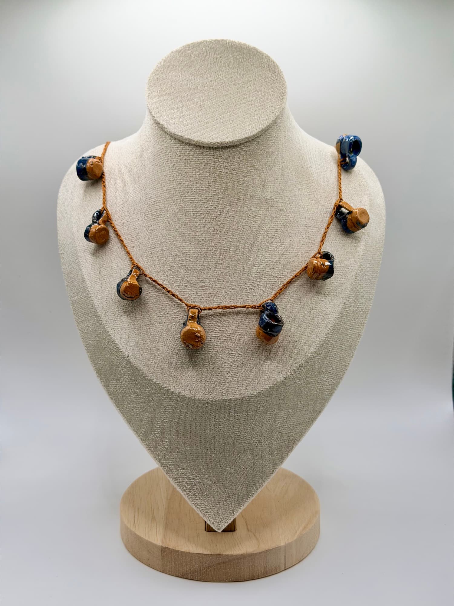Agua del Río displayed on a linen necklace bust.