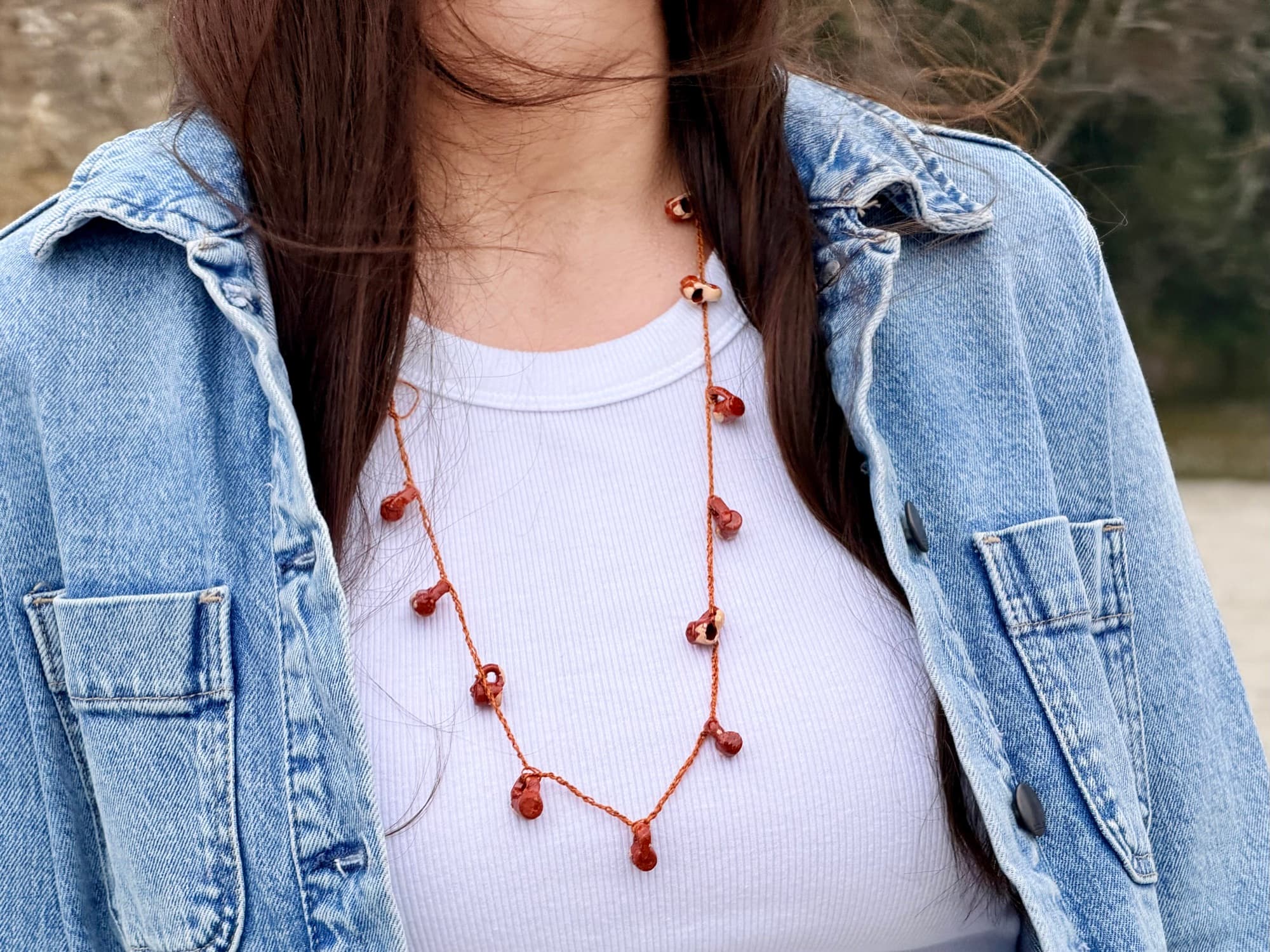 Canela y Barro worn with a white top and denim jacket outdoors.